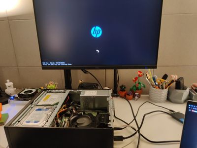 Opened desktop PC and a monitor showing its boot screen — the old NAS built from an HP desktop